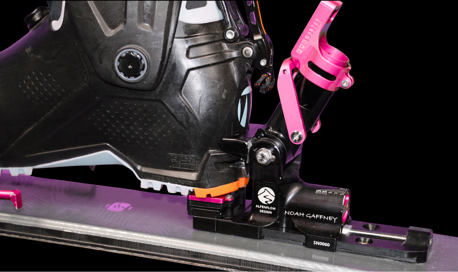 Close-up of a crossbow with pink nocking block and black sight on a black background